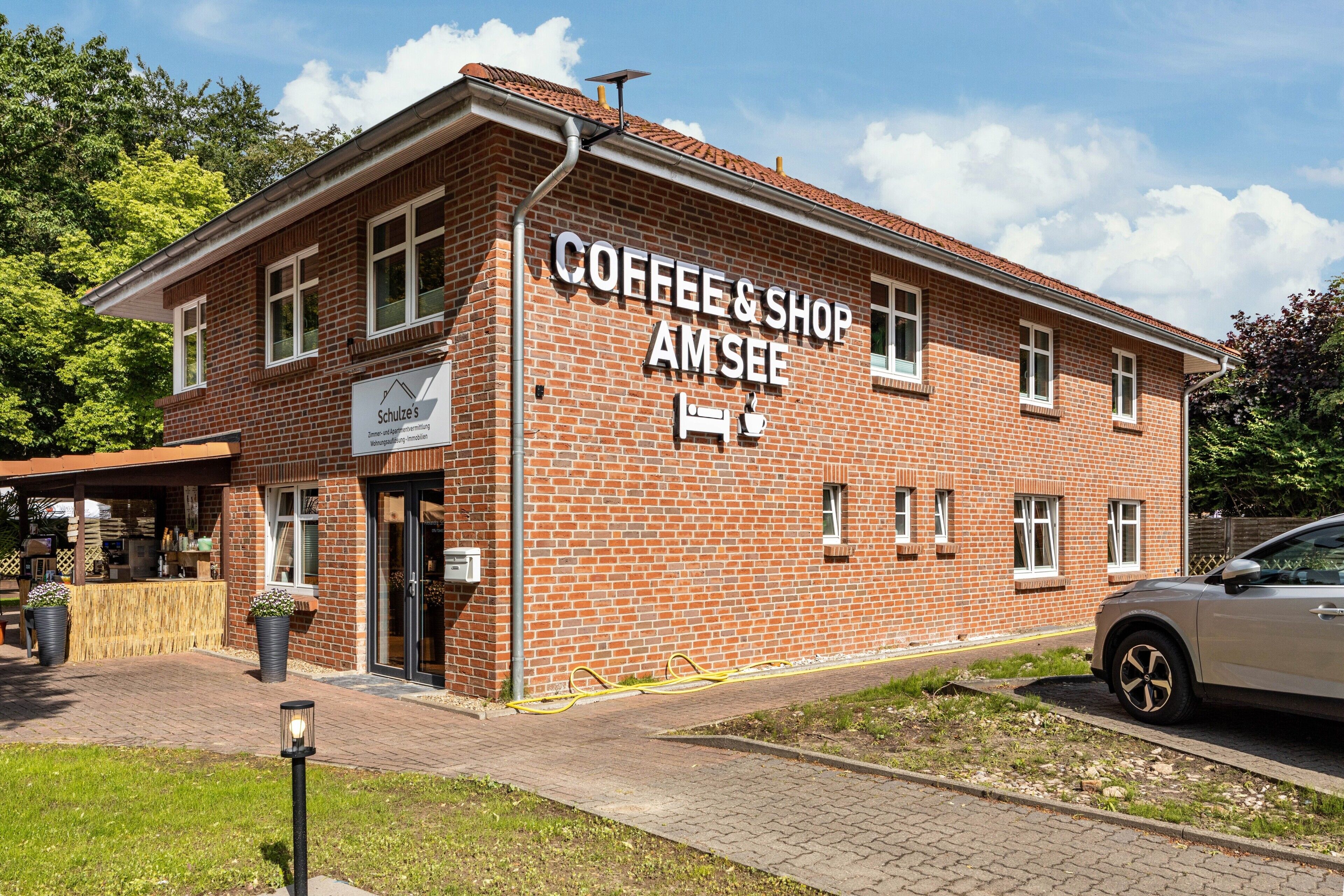 Un bâtiment en briques sur lequel on peut lire l’inscription : « Coffee & Shop AM SEE ».