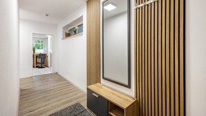 Una habitación moderna con un espejo grande, panel de pared de madera y un escritorio con silla.