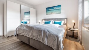 Un dormitorio moderno con cama, mesita de noche y una obra de arte colgada en la pared.