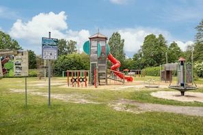 A playground with a slide, climbing structures, and a tower with a slide. - Apartment 'Seaside' with Wi-Fi (Bad Bodenteich)