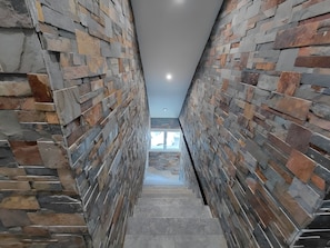 A staircase with stone walls and a view to the top of the building.