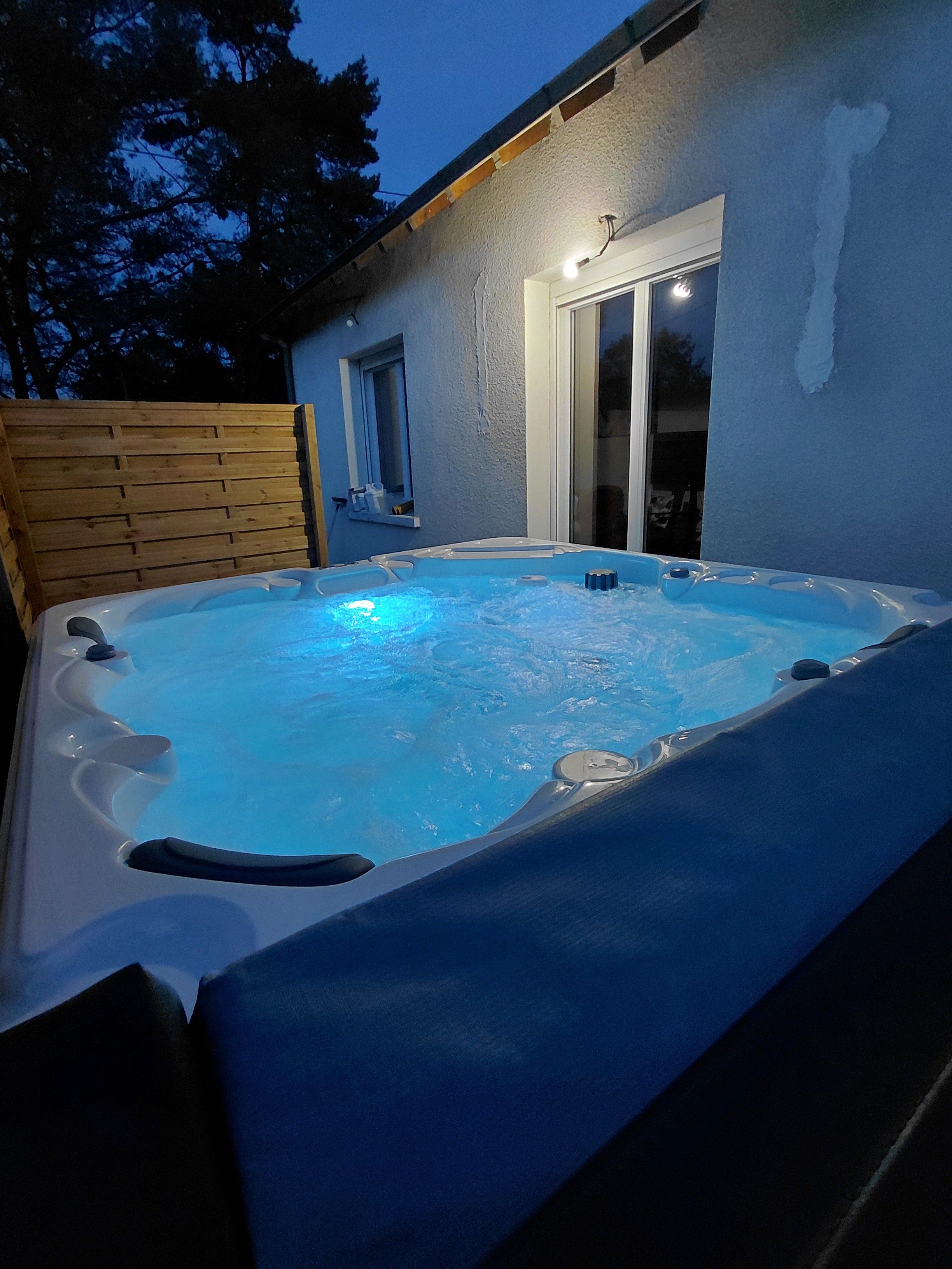 Un bain à remous avec une terrasse en bois et une fenêtre.