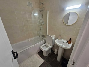 Un baño con bañera, inodoro, lavabo y cabina de ducha.