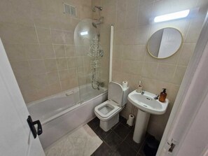 Un baño con bañera, inodoro, lavabo y cabina de ducha.