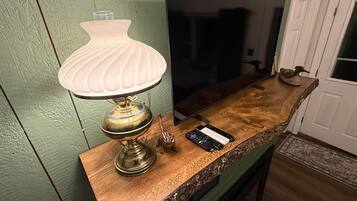 A kitchen counter with a white lamp, a smartphone, and a decorative item.