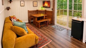 Una sala de estar acogedora con un sofá, un banco de madera y una chimenea.