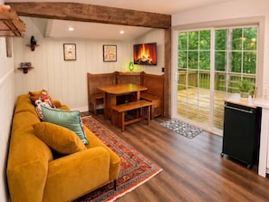 A cozy living room with a sofa, wooden bench, and a fireplace.