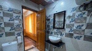 Een badkamer met toilet, wastafel, spiegel en douche.