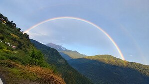 Een berglandschap met een regenboog boven het gebied.