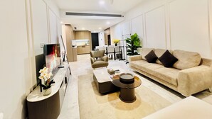 Ein modernes Wohnzimmer mit Sofa, Couchtisch, Fernseher und Deckenventilator.