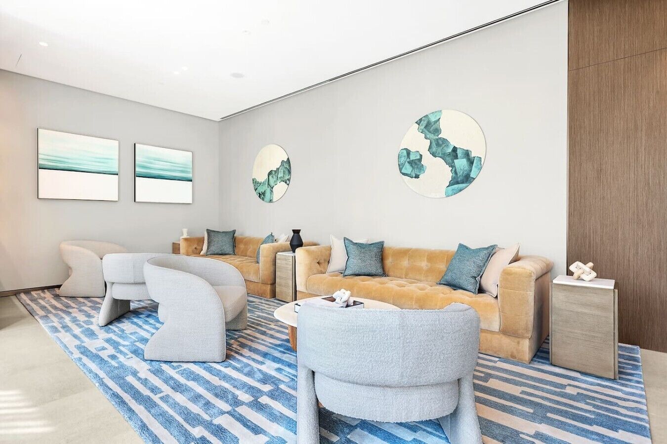 Ein modernes Wohnzimmer mit einer Sofagarnitur, einem Couchtisch und abstrakter Wandkunst.