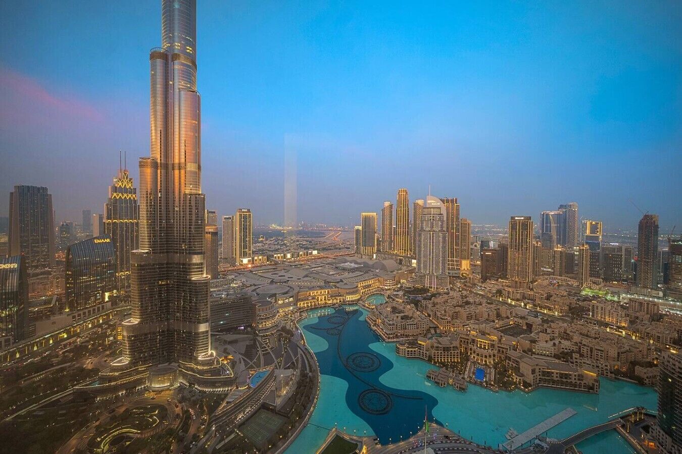 A cityscape with a prominent skyscraper, a river, and surrounding high-rise buildings.