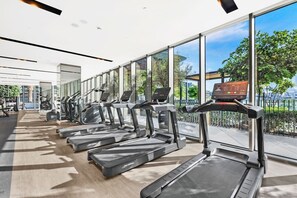 A gym with treadmills, exercise bikes, and weights. - FIRST CLASS | 1BR | Burj Khalifa & Fountain View (Downtown)