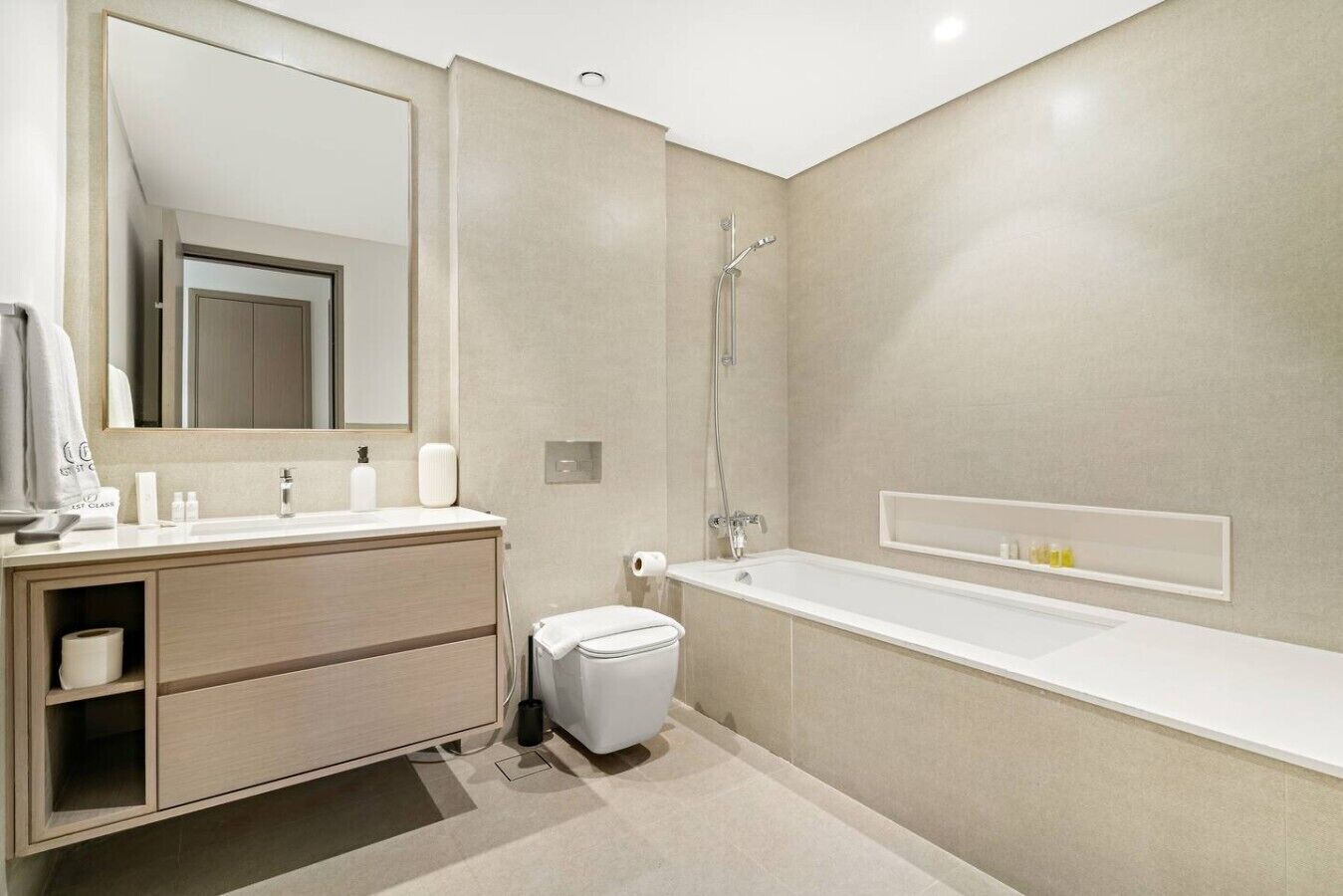Een moderne badkamer met een wastafel, toilet en bad.