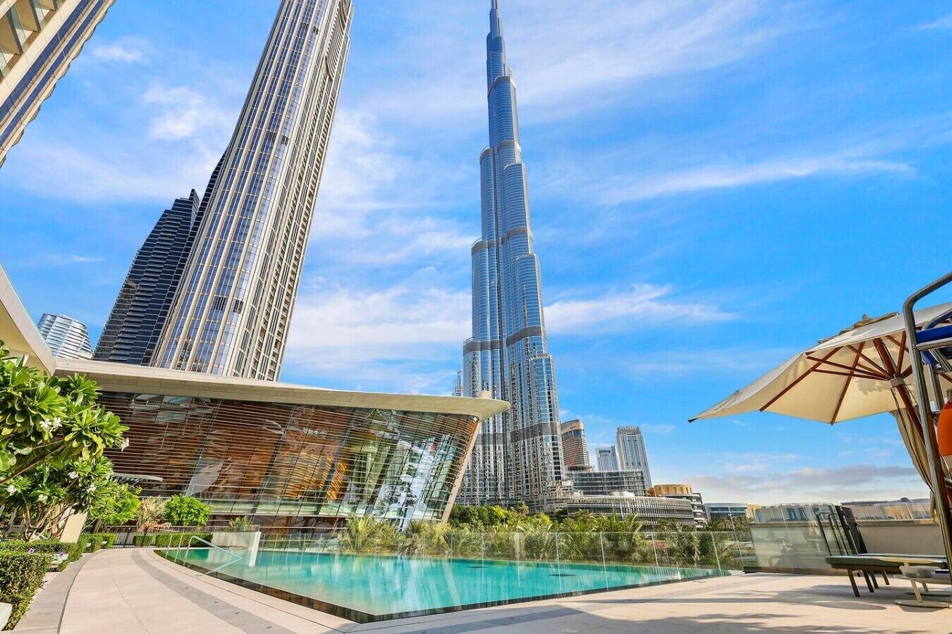 A rooftop pool area with a view of the Burj Khalifa.