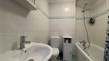 A bathroom with a sink, toilet, and bathtub.