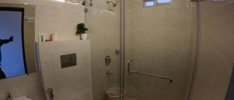 Ein Badezimmer mit Duschkabine, Waschbecken und Toilette.