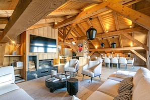 A spacious loft-style room with a fireplace, modern seating, and a dining area.