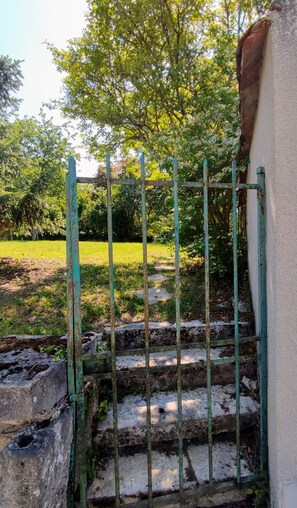 Une grille métallique avec des marches menant à un bâtiment.