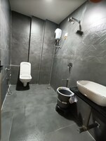 A modern bathroom with a toilet, bidet, and sink.