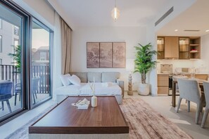 A modern living room with a sofa, coffee table, and dining area. - FIRST CLASS | 2BR | Relax & Unwind | Creek Beach (Dubai Creek Harbour)