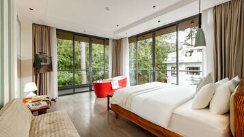 A modern hotel room with a large bed, a red bath tub, and a view of the outdoors.
