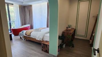Suite Mewah, balkon, pemandangan kebun | Meja kerja, tirai kedap cahaya, setrika/meja setrika, dan Wi-Fi gratis