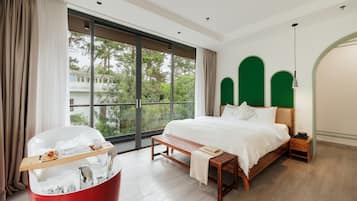 A modern hotel room with a large window, a wooden bed, a red bathtub, and a bench.
