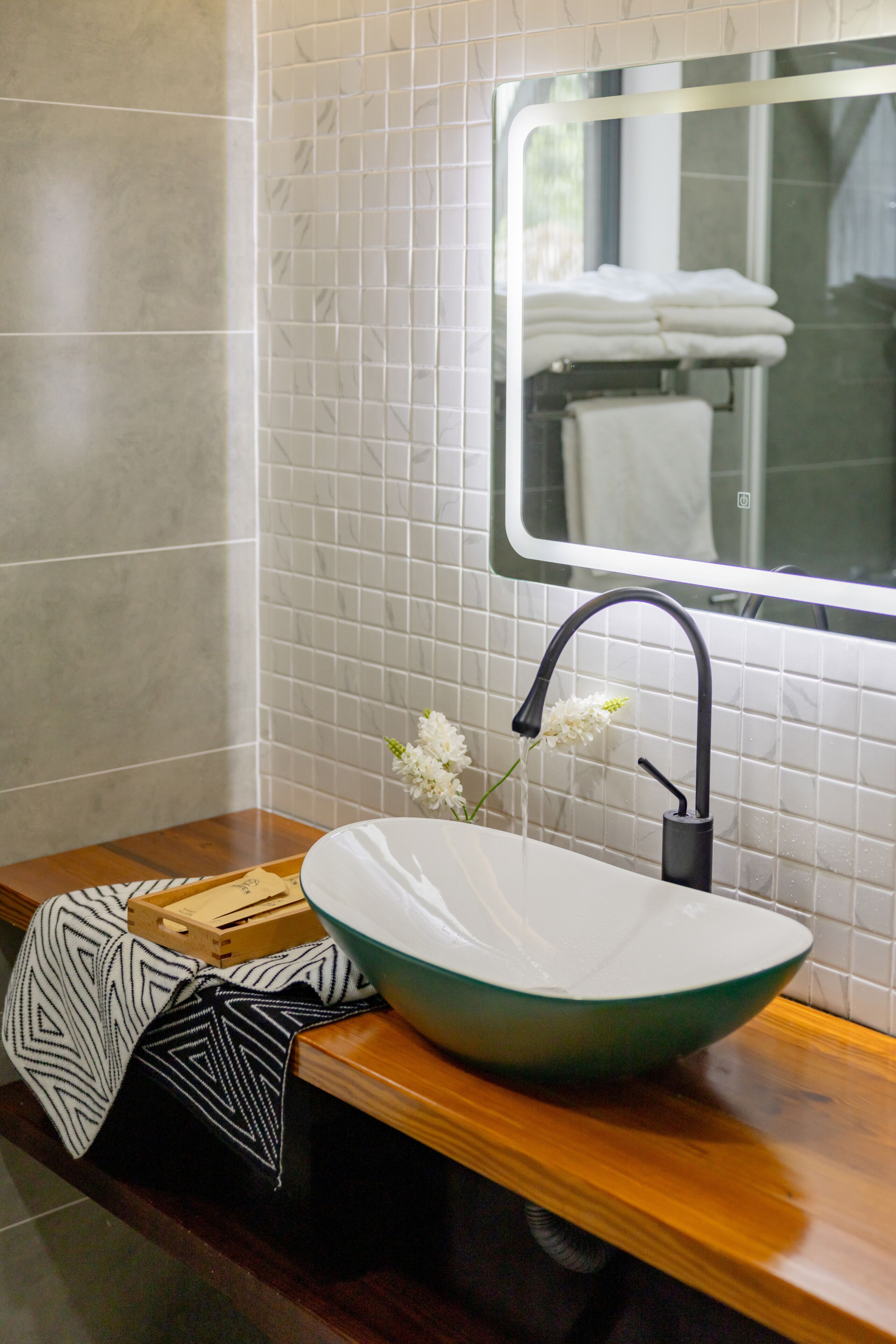 Une salle de bain avec un lavabo sur colonne, un miroir et un porte-serviettes.