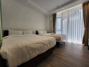 A hotel room with two beds, a large window with sheer curtains, and a wooden floor. - HAKU Boutique Hotel Da Lat - Ly Tu Trong (Da Lat)