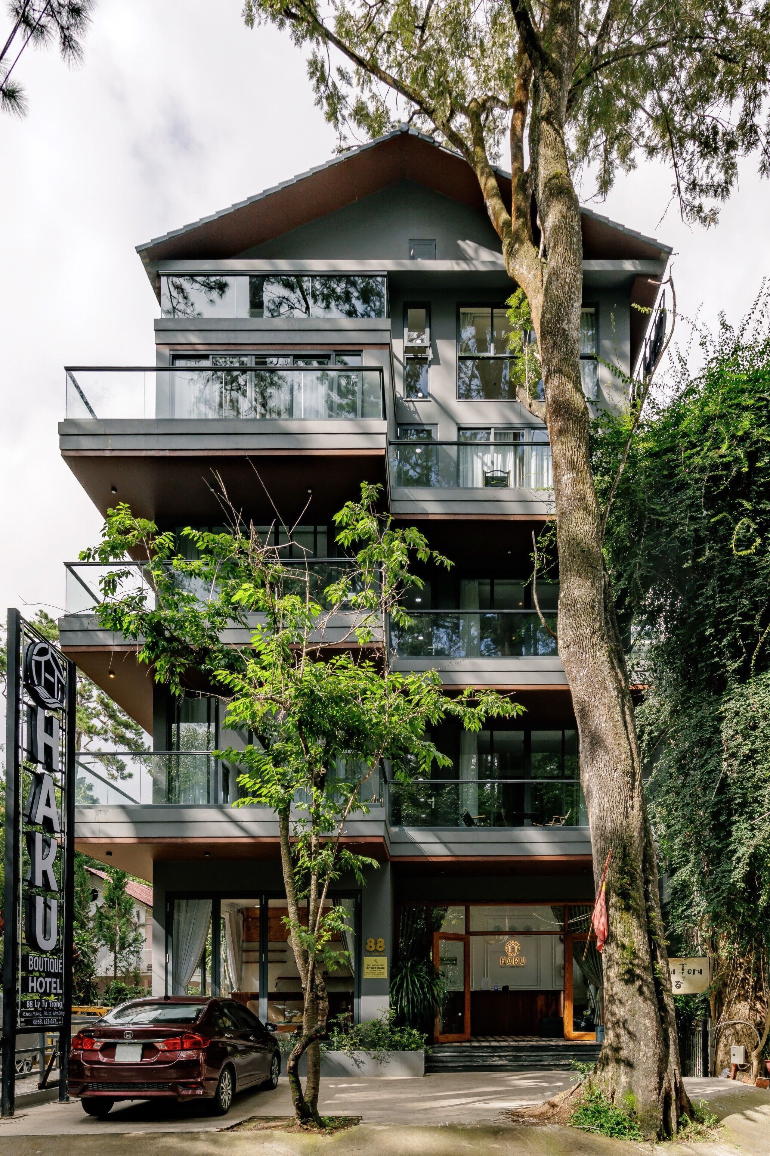 A multi-story hotel with a modern design, featuring balconies and large windows.
