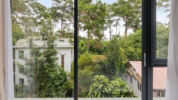 A view from a window with a view of a building surrounded by trees.