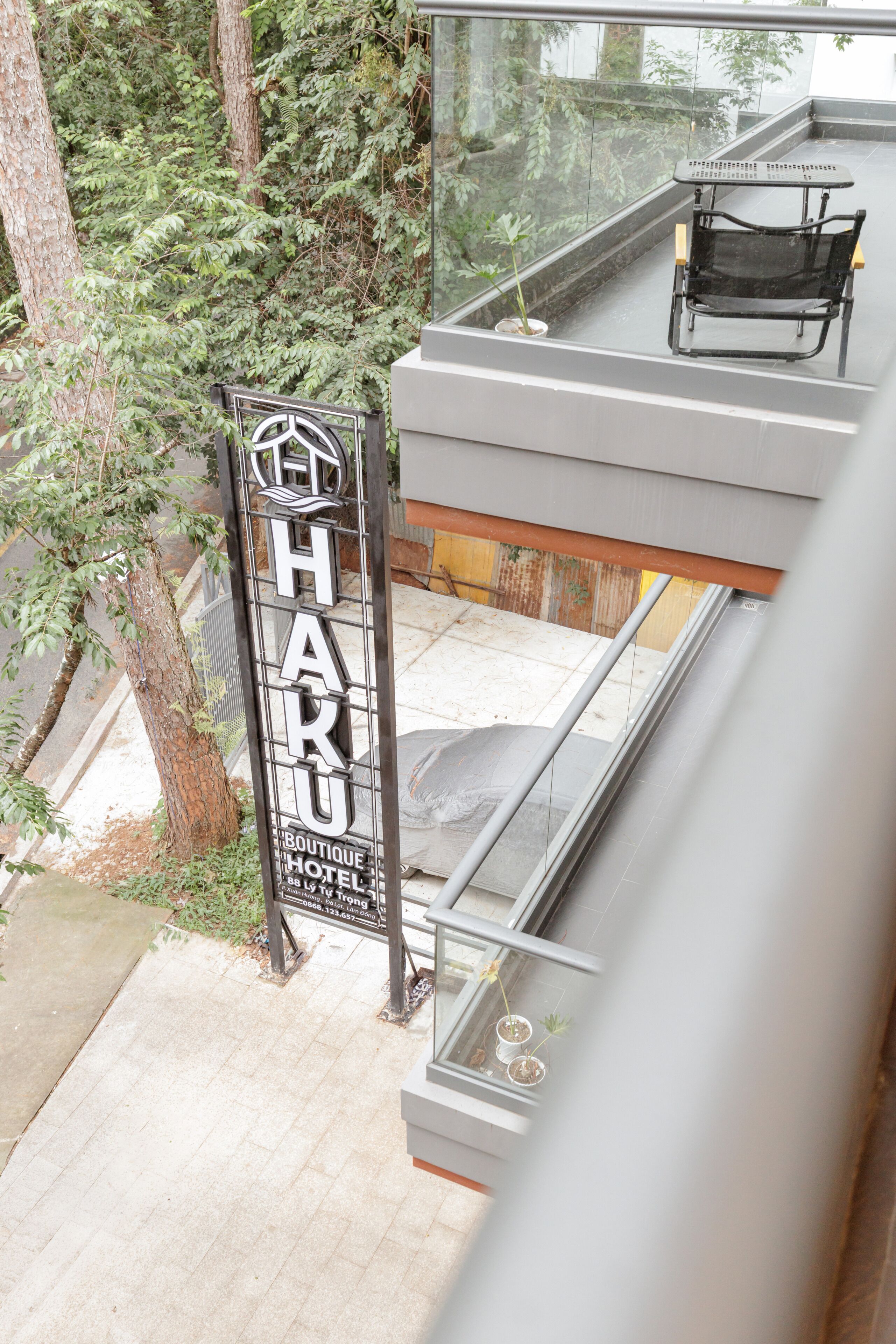 A hotel sign with the name 'HART' and a balcony with a chair.