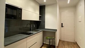 Una cocina moderna con horno empotrado, un lavamanos y una encimera.