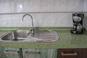 A kitchen with a stainless steel sink, a coffee maker, and green countertops. - Sol y Luna · house with terrace and barbecue in Caleta de Fuste (Castillo Caleta de Fuste)