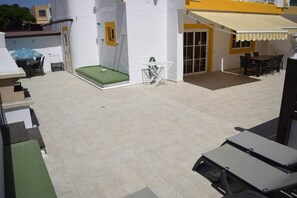 A rooftop patio with a green cushioned seating area, a small table, and a water fountain. - Sol y Luna · house with terrace and barbecue in Caleta de Fuste (Castillo Caleta de Fuste)