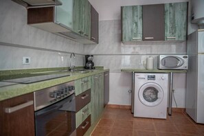 A compact kitchen with a washing machine, a microwave, and a coffee maker. - Sol y Luna · house with terrace and barbecue in Caleta de Fuste (Castillo Caleta de Fuste)