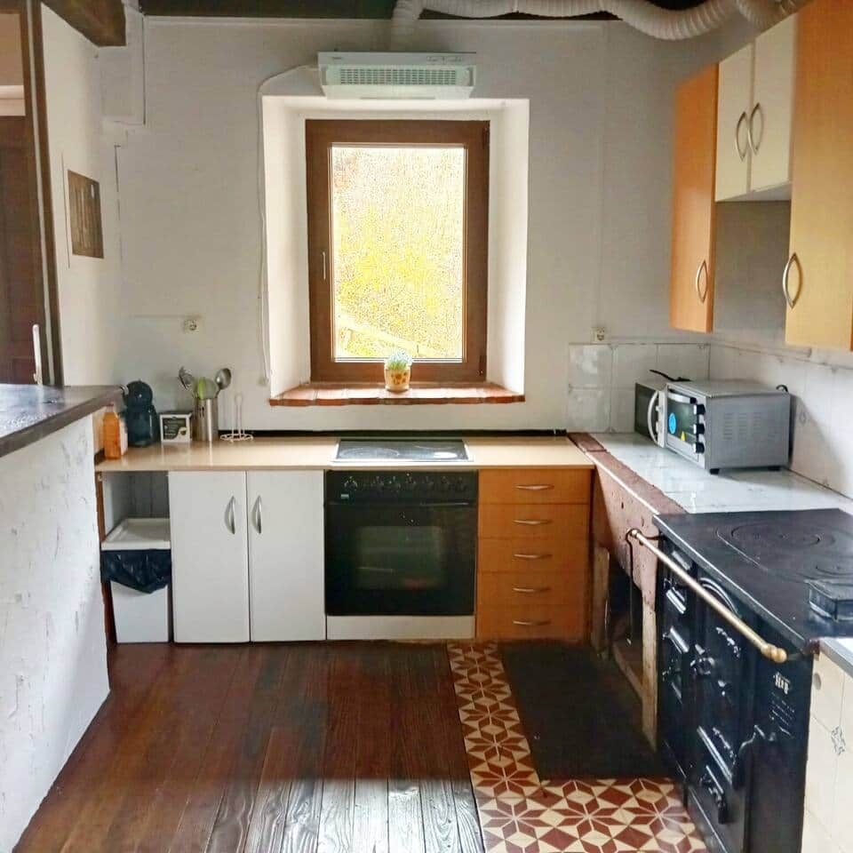Eine kompakte Küche mit integriertem Backofen, einer Mikrowelle und einem Herd.