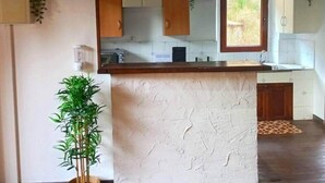 A kitchen with wooden cabinets, a central island, and a window.