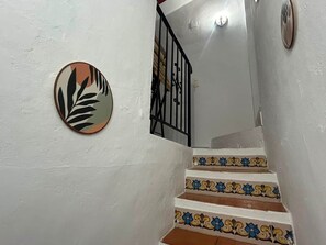 A staircase with white walls, a metal railing, and patterned tiles. - Village house with terraces and a barbecue in Teulada, Costa Bla (Teulada, Spain)