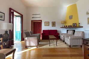 A living room with striped armchairs, a red sofa, and a wooden coffee table. - Private suite with views · Quinta da Agrela (Portugal) (Vade (São Pedro))