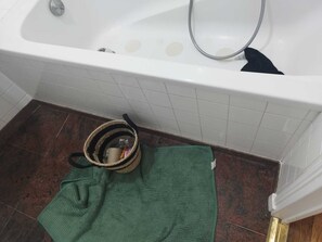 A bathroom with a white bathtub, a green towel, and a wicker basket on the floor. - BEAUTIFUL 2-BEDROOM APARTMENT IN LA POSTE, 22 AV. JEAN JAURES (Drancy)