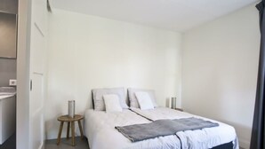 A modern bedroom with a bed, bedside tables, and a nightstand.