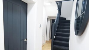 Eine Treppe mit Handlauf, einer Tür und einer Leuchte.