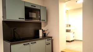 Uma cozinha compacta com micro-ondas, pia e armários.