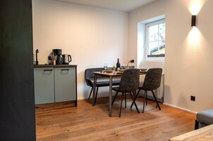 Una cocina pequeña con una mesa de comedor, sillas y un ventanal.