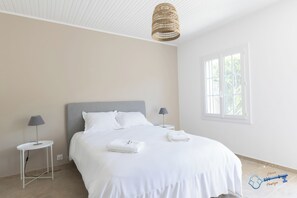 A hotel room with a bed, two bedside tables, a hanging light fixture, a window, and a door. - L'Écrin de Provence – Villa for 8 people with a pool (Entraigues-sur-la-Sorgue)