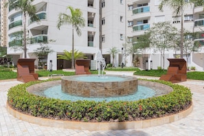 A modern building with a circular water feature surrounded by greenery. - Vossa Bossa Cadoro (São Paulo)