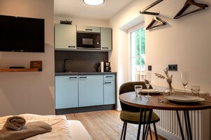 Una cocina compacta con microondas, cafetera y comedor con mesa dispuesta para dos.
