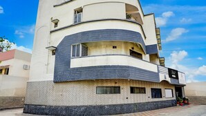 A multi-story hotel with a curved facade, balconies, and a sign indicating it is a hotel. - Super Collection O Hingna Road (Nagpur)